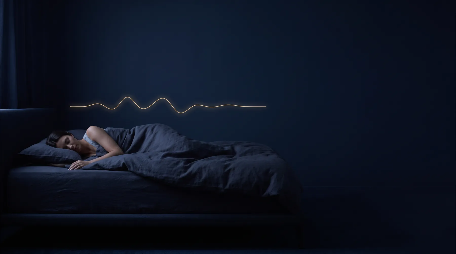 A person asleep in a dark bedroom beneath a glowing breathing waveform